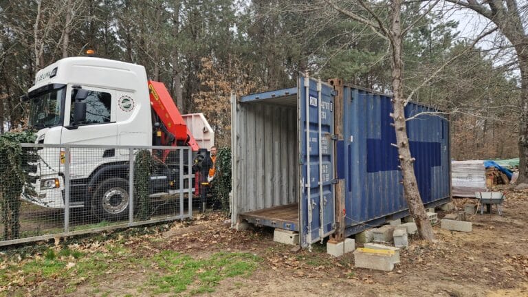 Container maritime 20 pieds bleu en forêt avec camion grue DE LIMA