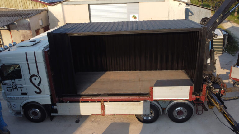 Image d'un container de 20 pieds chargé dans un camion en route pour être transformé pour le projet "La Grande École" au Havre par In'BOX GROUP