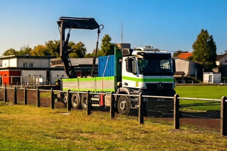 Camion grue livrant un container 6 pieds bleu au stade Pareau de Coulounieix-Chamiers pour la radio RLP