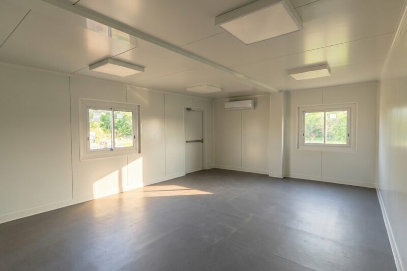 Intérieur de bureau en container aménagé, murs blancs, sol vinyle gris et éclairage LED, à Macau en Gironde