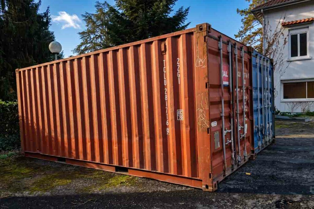 Container 20 pieds d'occasion rouge oxyde vu de trois quarts, posé sur la cour à Souillac (46)
