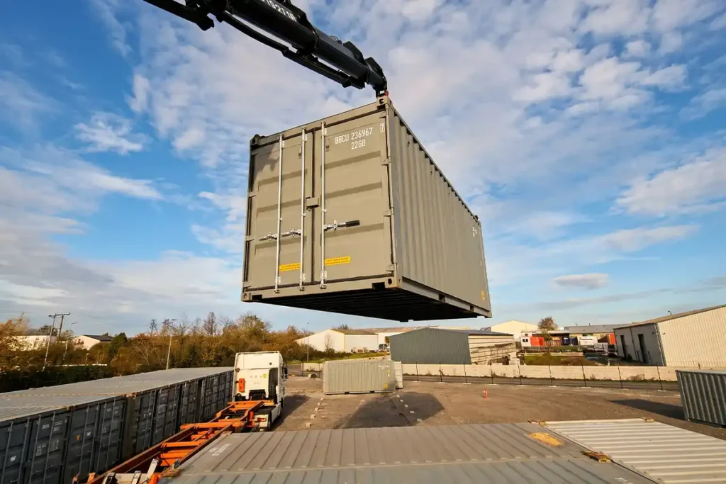 Container 20 pieds gris suspendu à la grue au-dessus d'un parc de self-stockage en Charente