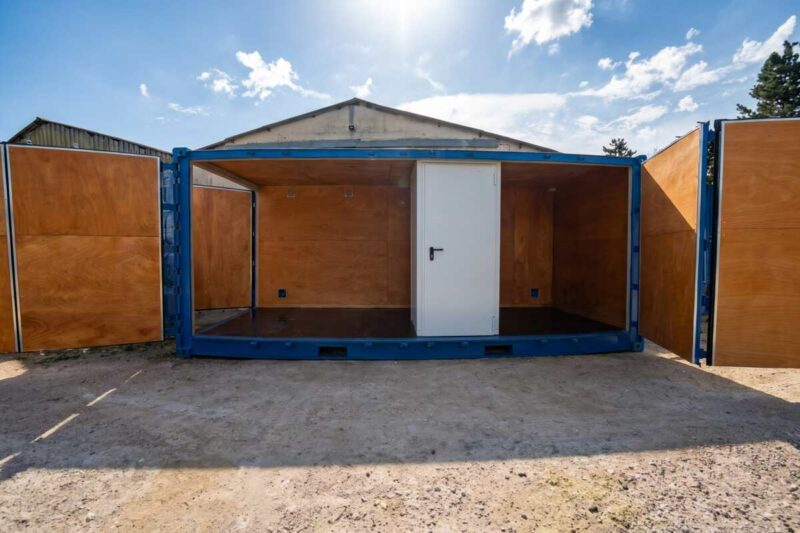 Container maritime open-side habillé de panneaux en contreplaqué marine, transformé en scène de théâtre de rue à La Réunion