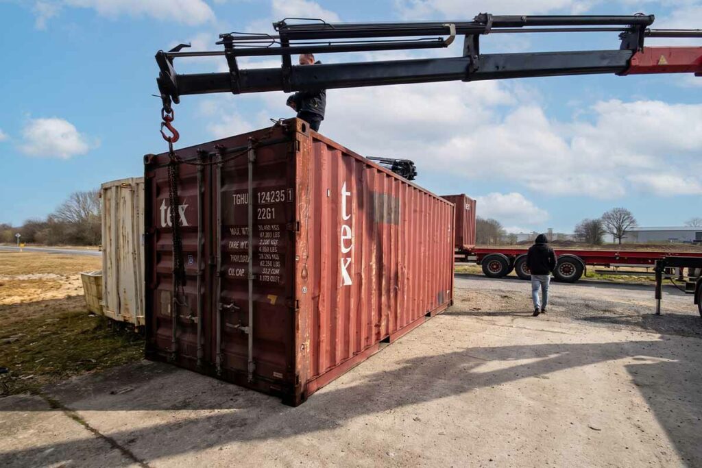 Déchargement d'un container 20 pieds d'occasion au camion-grue sur le site de CIP à Saint-Martial-d'Artenset