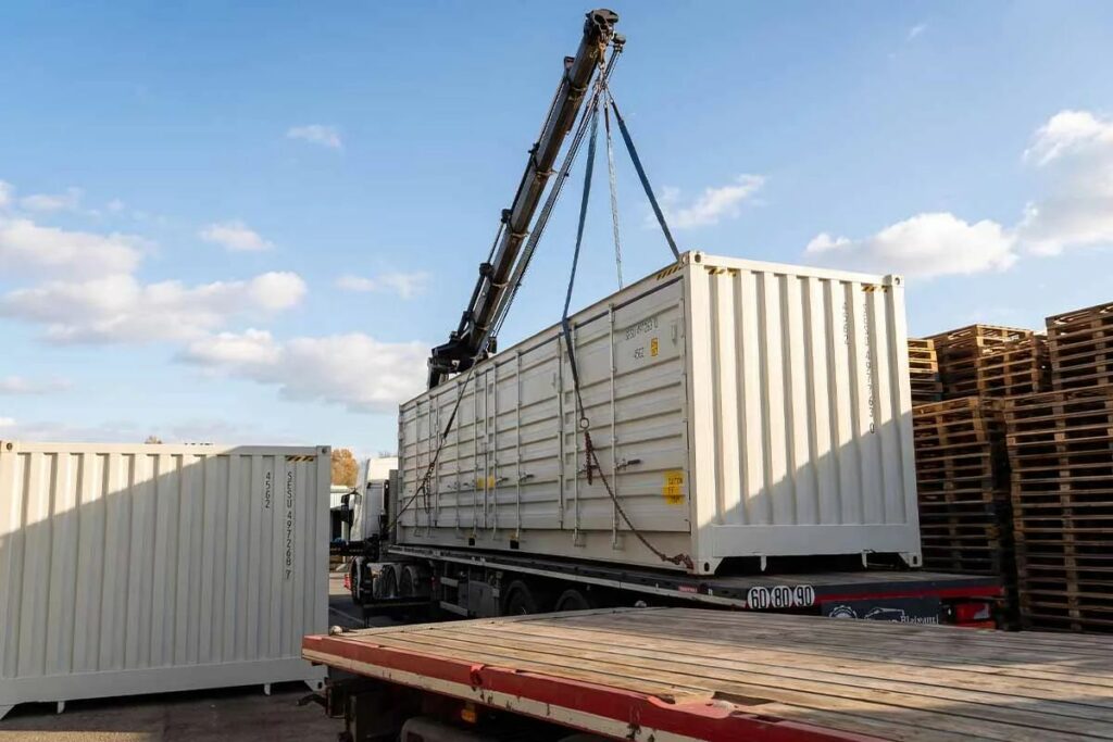 Deux containers 40 pieds open side gris clair déchargés au bras grue sur la cour de la cartonnerie, Saint-Seurin (33)