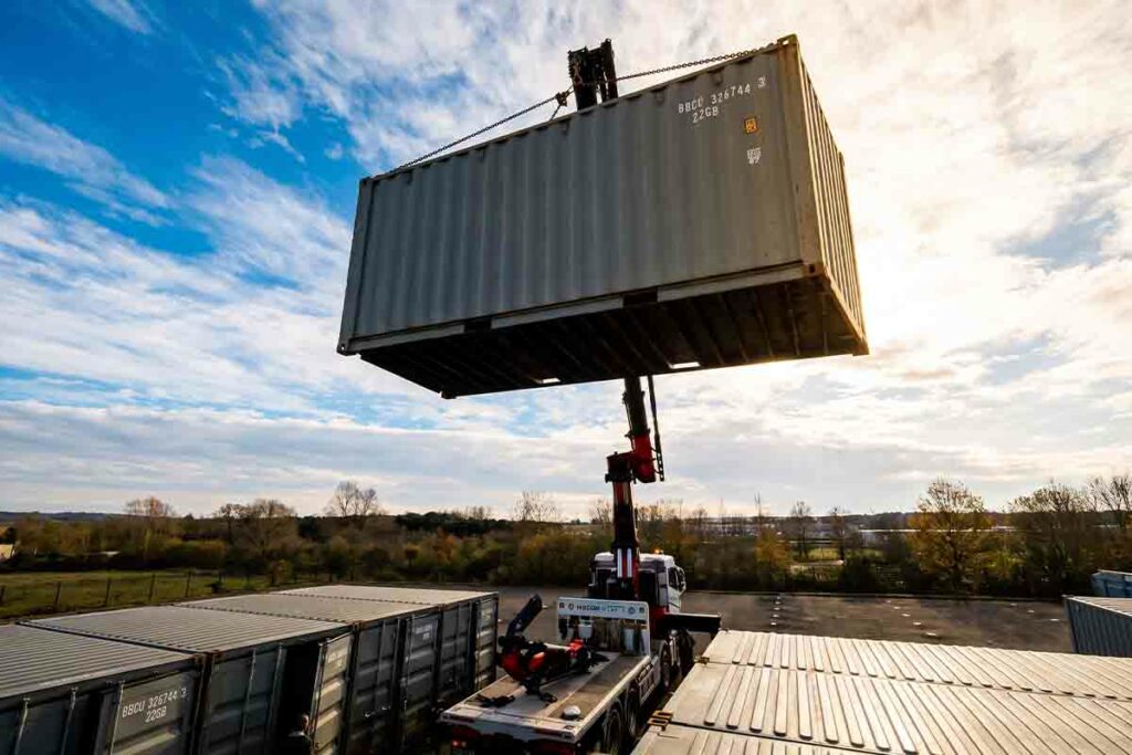 Rangées de containers 20 pieds gris formant les premières allées d'un parc de self-stockage