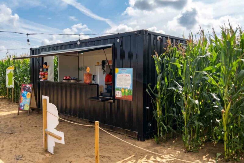Container noir habillé de bois, point de vente Pop Corn Labyrinthe en bordure d'un champ de maïs à Strasbourg
