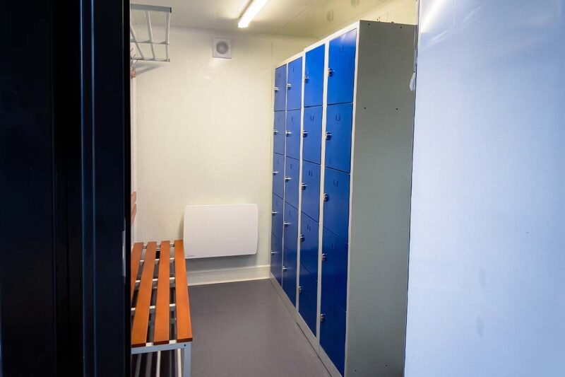 Intérieur de vestiaire aménagé en conteneur, avec casiers, banc bois et extracteur, pour Nordex à Méreau