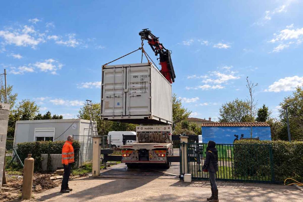Camion-grue de Nadon et Fils levant un container 20 pieds à l'entrée d'un portail, à Andilly en Charente-Maritime