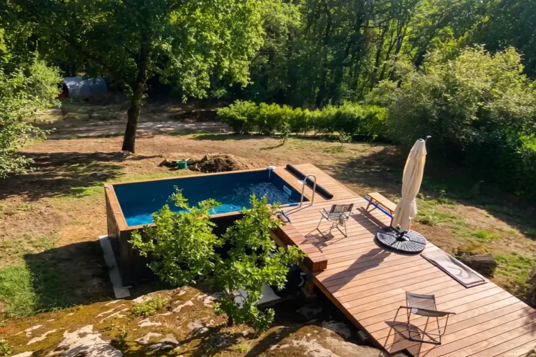 Piscine container hors sol bordée d'une terrasse en bois, sur un terrain rocheux en pente à Abjat-sur-Bandiat (24)